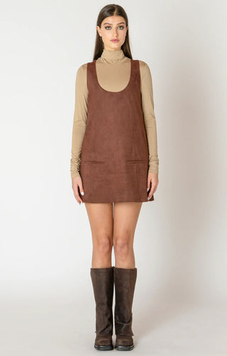 Woman wearing a brown suede dress with a plain background