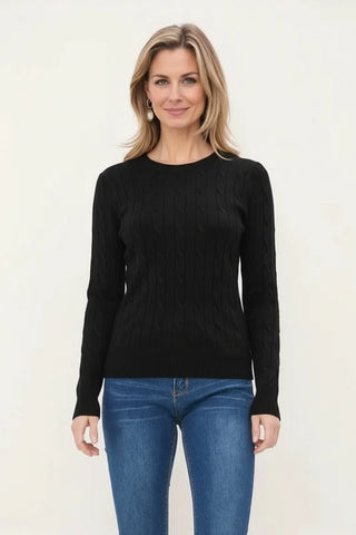 Woman wearing a black sweater and blue jeans on a white background